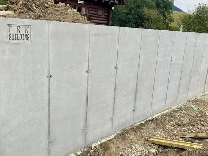 Oporný múr v Ižipovciach s logom TRK Building odtlačeným v betóne