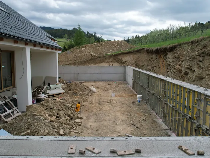 Dronový pohľad na výstavbu oporného múru pri rodinnom dome na svahovitom pozemku